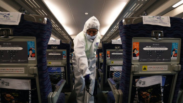 A disinfection worker in Seoul, South Korea, sprays anti-septic solution in a train amid rising public concerns over the spread of the coronavirus.
