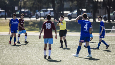 A young referee oversees a soccer match between Hakoah Sydney City East and APIA Leichhardt Tigers at Hensley Athletic Field in Eastlakes.
