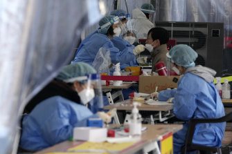 People undergo COVID tests at a makeshift testing site in Seoul on Thursday.