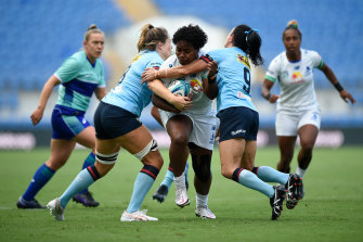 Fijiana’s Karalaini Naisewa is tackled by the Waratahs’ Iliseva Batibasaga and Grace Hamilton.