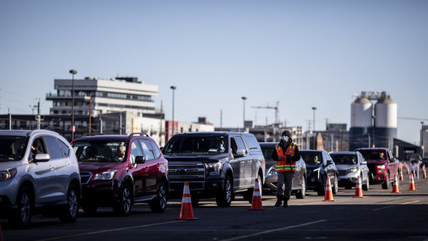 People wait in vehicles to receive a vaccine dose at Coors Field in Denver, Colorado.