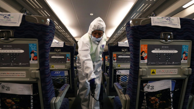 A disinfection worker in Seoul, South Korea, sprays anti-septic solution in a train amid rising public concerns over the spread of the coronavirus.