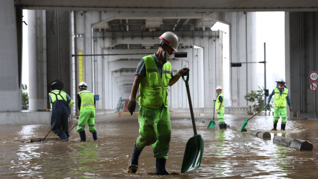 Workers begin the clean-up in the aftermath of a torrential storm that hit  Han River Park in Seoul.