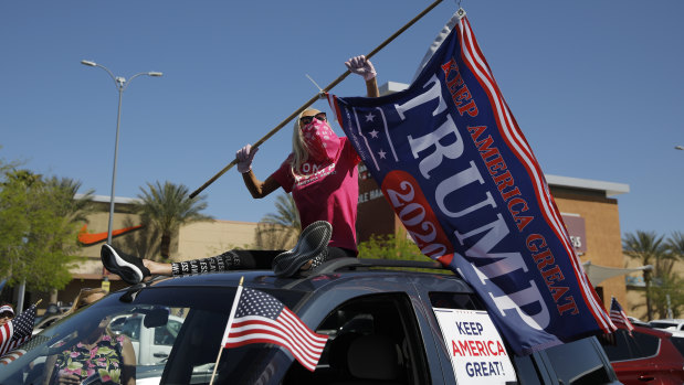 A woman holds a Donald Trump flag while protesting against stay-at-home orders in Las Vegas.
