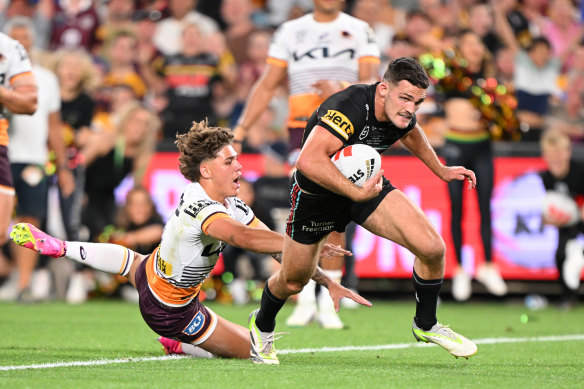 Nathan Cleary powers past Reece Walsh towards the try line.