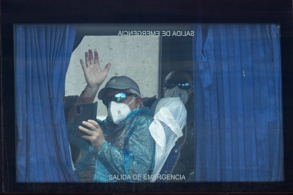 A passenger waves from a bus on the way to the airport after being evacuated from the MV Hondius after the cruise ship docked in Tenerife, part of the Canary Islands, Spain. 