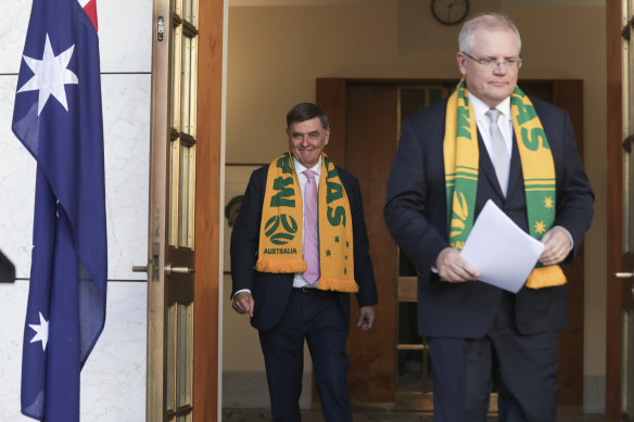 Chief Medical Officer Professor Brendan Murphy and Prime Minister Scott Morrison arrive wearing Matildas scarves as they address the media at Parliament House in Canberra on Friday. 