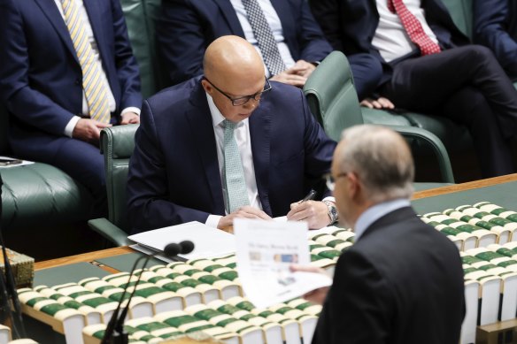 Prime Minister Anthony Albanese waves a photocopy of The Sydney Morning Herald front page at Opposition Leader Peter Dutton. 