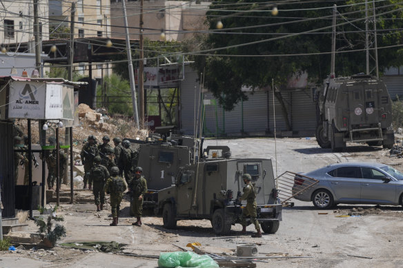 Israeli forces patrol a street during a military operation in the West Bank refugee camp of Al-Faraa.