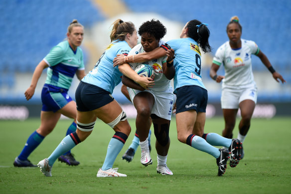 Fijiana’s Karalaini Naisewa is tackled by the Waratahs’ Iliseva Batibasaga and Grace Hamilton.