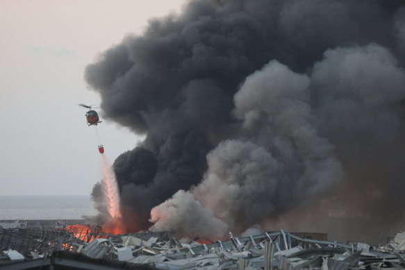 A helicopter drops water following a large explosion at the Port of Beirut in Beirut, Lebanon,  on August 4.