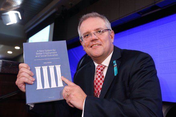 Scott Morrison, as the then social services minister, with the McClure report on welfare reform in 2015.