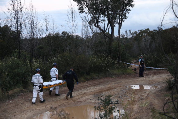 Police carry the body of Carroll, who was found dead by a bushwalker near Sandy Point quarry.