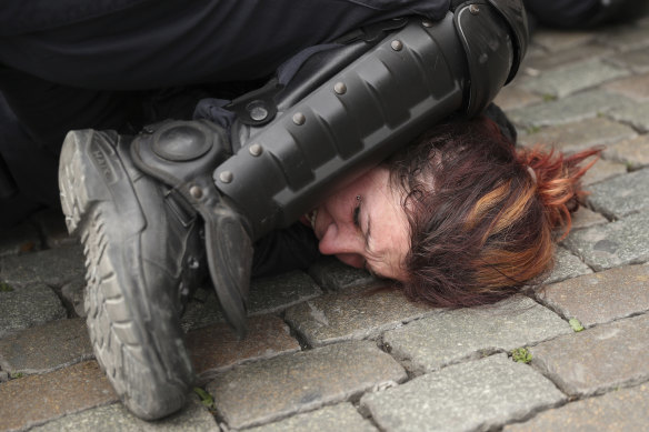 Police detain a woman during a yellow vest protest with other groups in Brussels in May, 2019.