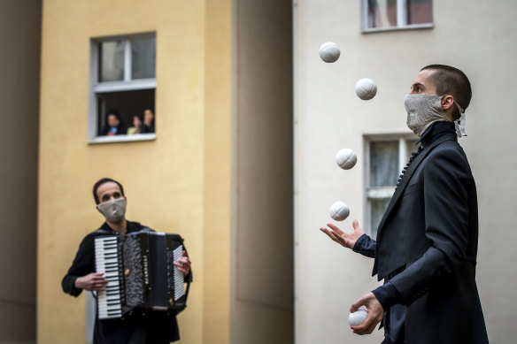 Residents of Prague watch entertainers during the lockdown.