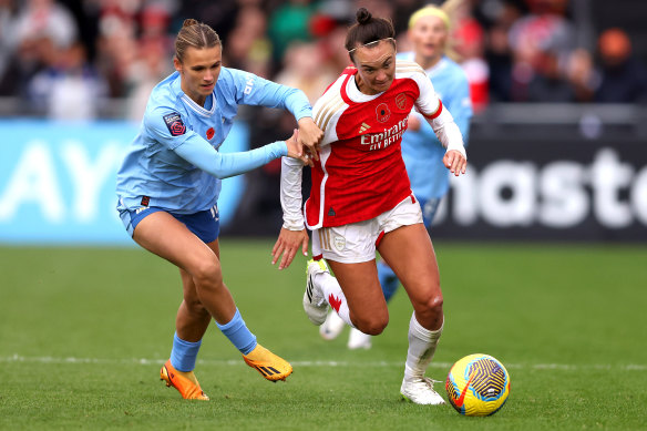 Caitlin Foord of Arsenal runs with the ball whilst under pressure from Kerstin Casparij.