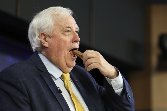 Clive Palmer, Trumpet of Patriots chairman, eats a TimTam during an address to the National Press Club of Australia.