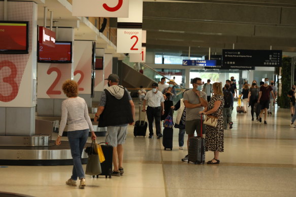 Passengers collect their bags after flying into Sydney from Melbourne.