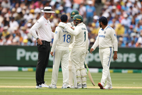 The umpire speaks to the players as Virat Kohli clashes with Sam Konstas.