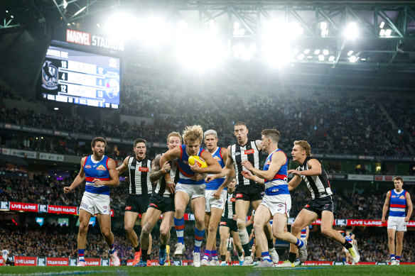 Ryley Sanders of the Bulldogs is tackled by Beau McCreery of the Magpies.