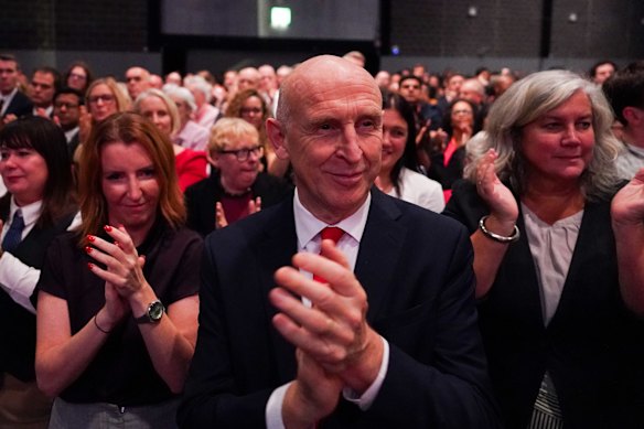 Chancellor of the Exchequer John Healey reacts as Burnham speaks.