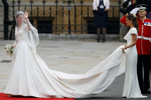 Kate Middleton in her Alexander McQueen wedding dress preparing to enter Westminster Abbey, with her sister Pippa carrying her train.