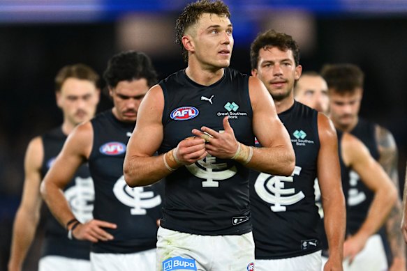 Blues skipper Patrick Cripps leads his side in after the loss to North Melbourne.