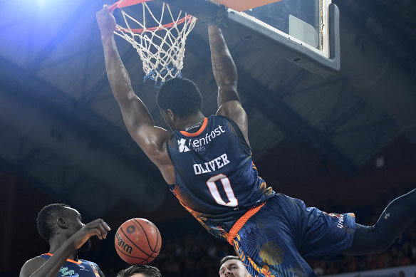 Cameron Oliver of the Taipans dunks over the Wildcats.