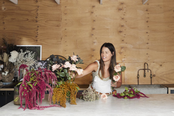 Alice in her backyard floristry studio, which was built before the house was renovated. “It has a large workbench, trough, and room for all the flowers I need for weddings and events,” she says.