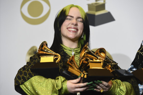 Billie Eilish poses with her Grammy Awards after the ceremony.
