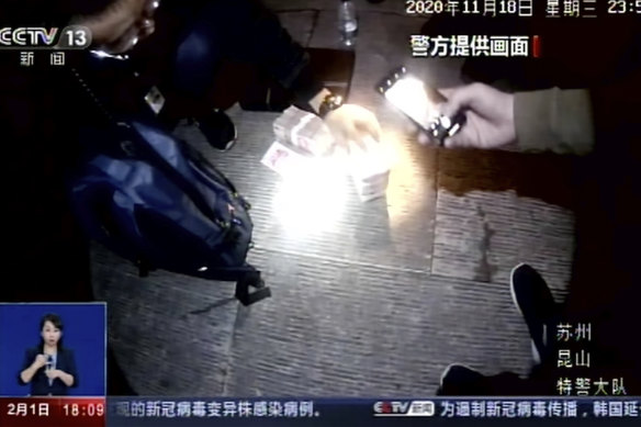 Policemen seize cash in China’s Jiangsu Province in 2020, where police have arrested more than 80 suspected members of a criminal group that was manufacturing and selling fake COVID-19 vaccines, including to other countries. 