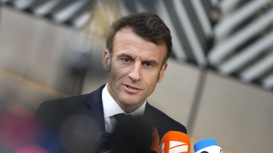 French President Emmanuel Macron speaks with the media as he arrives for an EU summit in Brussels.