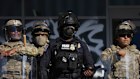 US customs officers and National Guard soldiers are posted outside a federal building in Los Angeles while protesters rally.