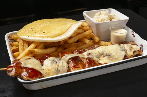 Chicken skewer with cheese, arepa (corn flatbread), chips and sweet cabbage.
