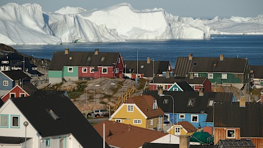 The town of Ilulissat with icebergs looming at the mouth of its fjord in July.