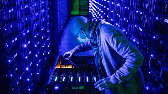 An employee wearing a protective face mask inspects Sapphire Technology Ltd. AMD graphics processing units (GPU) at the Evobits crypto farm in Cluj-Napoca, Romania