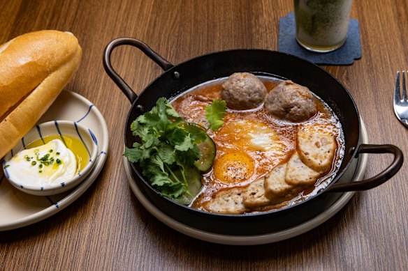 Banh mi chao: eggs, pork loaf, pâté, meat and pickled vegetables in a bubbling tomato skillet.