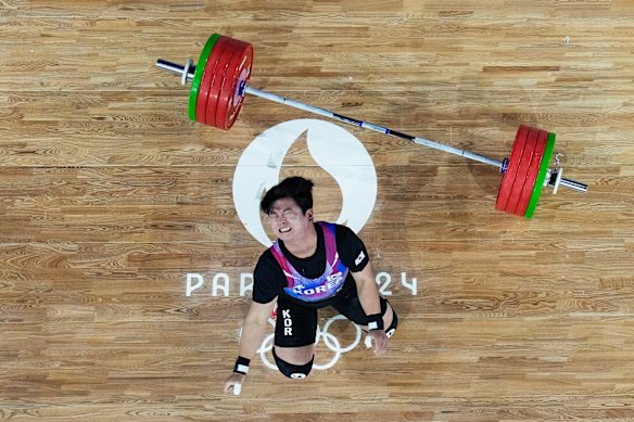 Joohyo Bak of South Korea reacts after completing a clean and jerk during the men’s weightlifting.