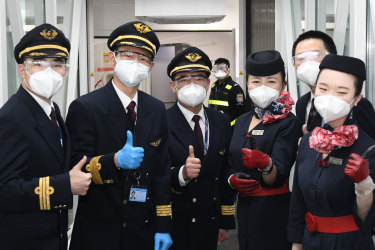 WUHAN, April 8, 2020. Crew members of flight MU2527 of China Eastern airlines pose for photos before takeoff at the Tianhe International Airport in Wuhan, central China’s Hubei Province, April 8, 2020. Wuhan on Wednesday lifted outbound travel restrictions, after almost 11 weeks of lockdown to stem the spread of COVID-19. (Photo by Cheng Min/Xinhua via Getty) (Xinhua/Cheng Min via Getty Images) Getty image for Traveller. Single use only.