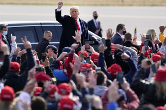 President Donald Trump acknowledges supporters as he leaves a campaign rally at Manchester-Boston regional airport, on Sunday (Monday AEDT).