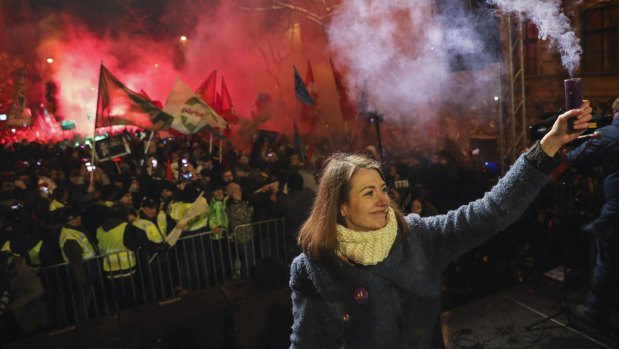 Vice-chairperson of Momentum party Anna Donath holds up a smoke grenade during an anti-government protest in Budapest, Hungary, on Sunday.