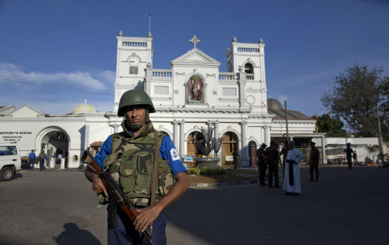 Sri Lankan military and clergy stand outside St Anthony's Shrine a day after the Easter Sunday attacks. 