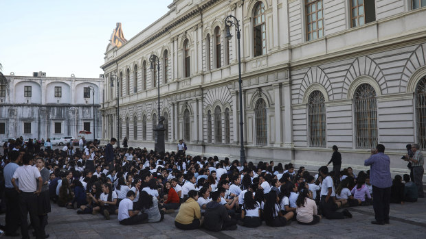 Students from a public school sit in an open area after being evacuated, in Veracruz, Mexico last year.