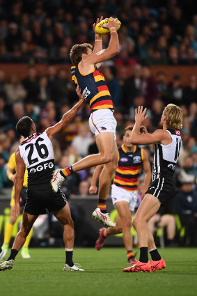 Riley Thilthorpe of the Crows marks over Miles Bergman of Port Adelaide. 