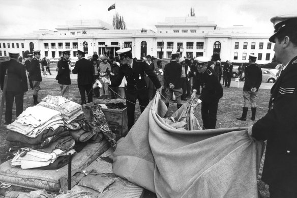 Police remove tents and bedding from the the lawns of Parliament House.