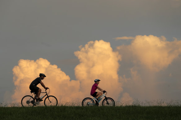 People ride bikes on the Mississippi River levee in Jefferson Parish, a suburb of New Orleans, Louisiana. The state's representative in Congress is against Joe Biden's climate plans.