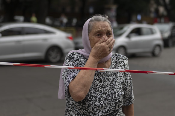 A woman reacts as she stands outside the damaged church in Odesa.