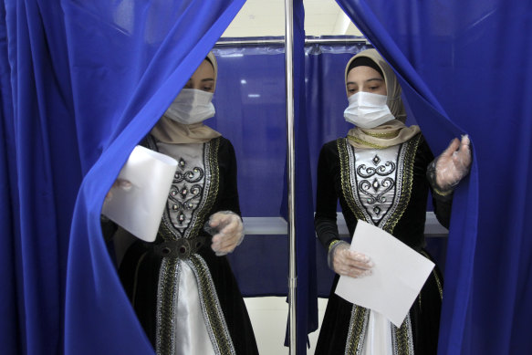 Chechen women in traditional dress leave a polling booth in Grozny, Russia, on Sunday.