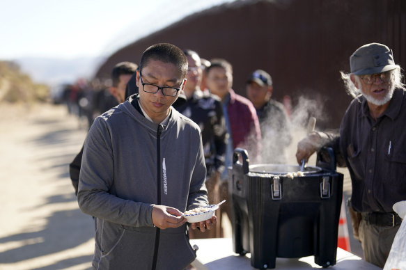 A man from China gets a bowl of oatmeal from a volunteer near Jacumba, California, after crossing from Mexico.