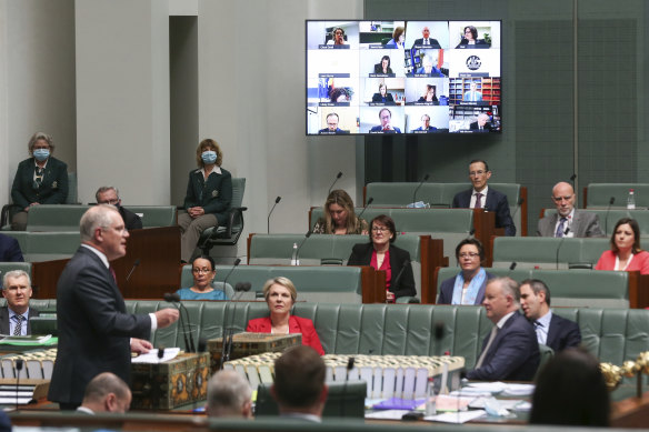 Prime Minister Scott Morrison responds to a question as "remote" MPs hover over the chamber. 